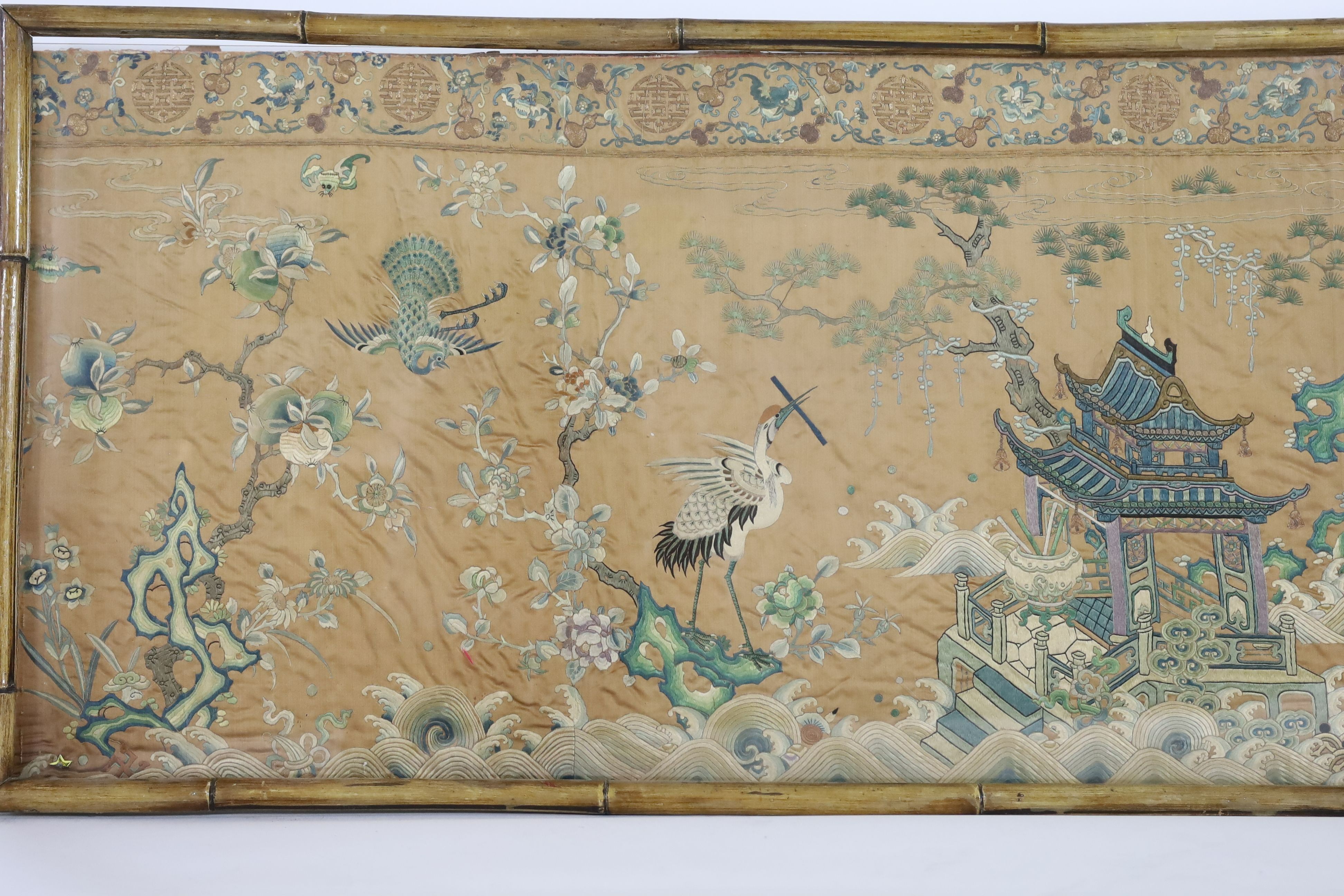 A Chinese apricot ground embroidered silk table frontal, late Qing dynasty, 58cm x 178cm, now trimmed and framed